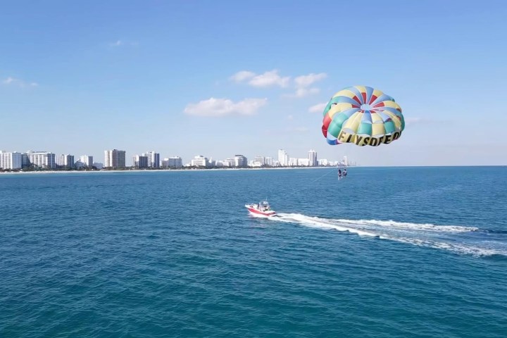 a person flying a kite in a large body of water