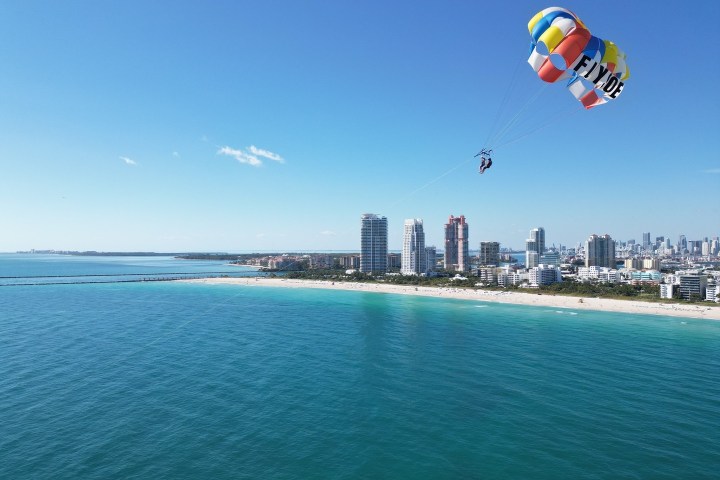 a person flying a kite in a large body of water